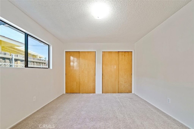 40389 Melrose Ave, Hemet, CA 92544 - unfurnished bedroom featuring multiple closets, a textured ceiling, and carpet