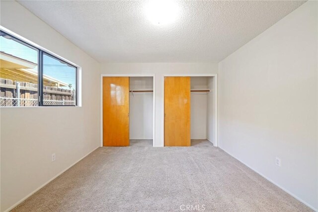 40389 Melrose Ave, Hemet, CA 92544 - unfurnished bedroom featuring multiple closets, a textured ceiling, and carpet flooring