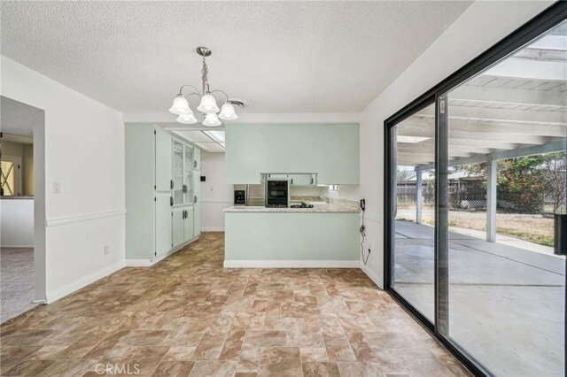 40389 Melrose Ave, Hemet, CA 92544 - kitchen with stainless steel fridge, stone finish flooring, a chandelier, light countertops, and a peninsula