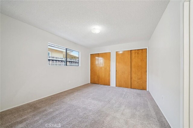 40389 Melrose Ave, Hemet, CA 92544 - unfurnished bedroom with multiple closets, carpet, and a textured ceiling