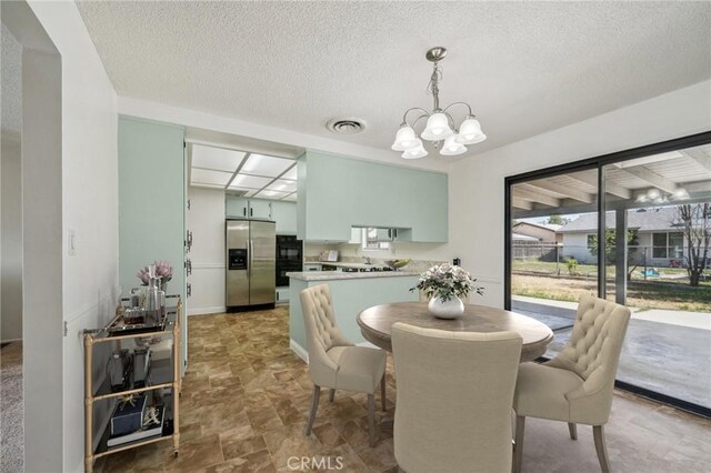 40389 Melrose Ave, Hemet, CA 92544 - dining room featuring a chandelier, stone finish flooring, a textured ceiling, and baseboards