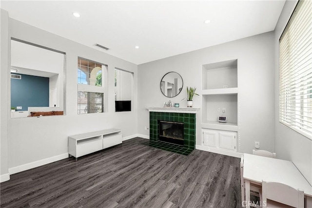 unfurnished living room with wood finished floors, healthy amount of natural light, a fireplace, and recessed lighting