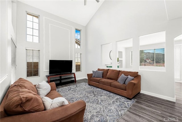 living area featuring high vaulted ceiling, baseboards, wood finished floors, and a ceiling fan