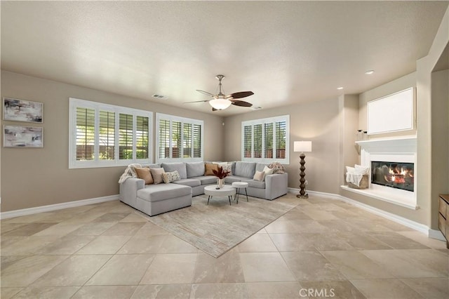 45133 Fieldbrook Ct, Temecula, CA 92592 - living room featuring a ceiling fan, baseboards, a glass covered fireplace, light tile patterned floors, and recessed lighting