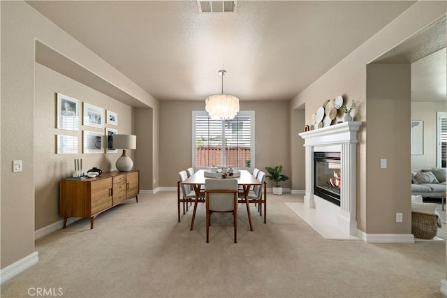 45133 Fieldbrook Ct, Temecula, CA 92592 - dining space with light colored carpet, a chandelier, a fireplace with flush hearth, and baseboards