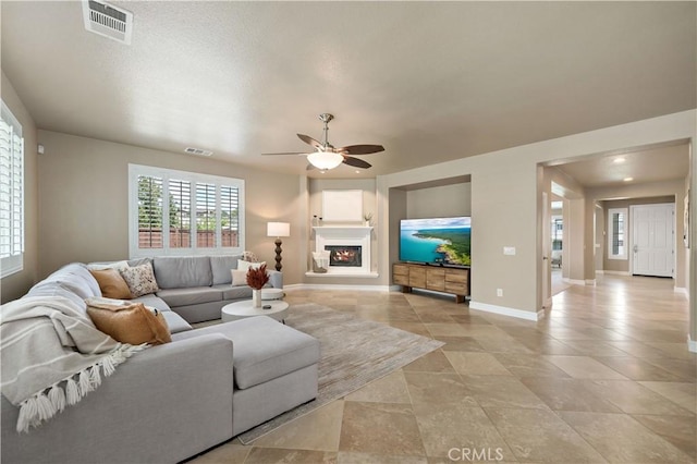 45133 Fieldbrook Ct, Temecula, CA 92592 - living room with a ceiling fan, baseboards, plenty of natural light, and a fireplace