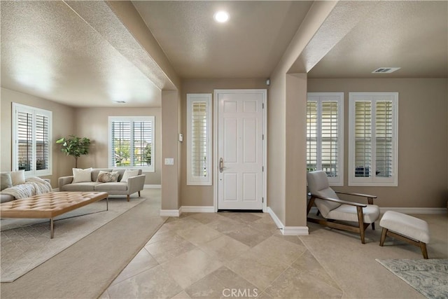 45133 Fieldbrook Ct, Temecula, CA 92592 - foyer with baseboards, a textured ceiling, light tile patterned flooring, and light carpet