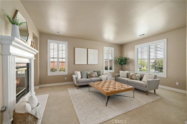 45133 Fieldbrook Ct, Temecula, CA 92592 - living area featuring light colored carpet, a textured ceiling, a glass covered fireplace, and baseboards
