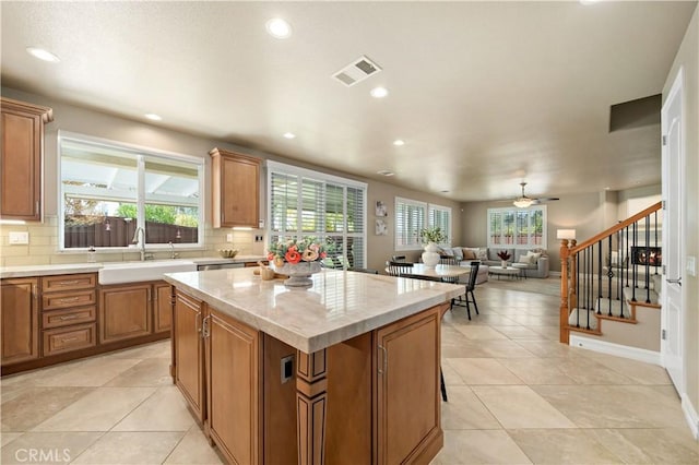 45133 Fieldbrook Ct, Temecula, CA 92592 - kitchen with a sink, decorative backsplash, a center island, brown cabinets, and recessed lighting