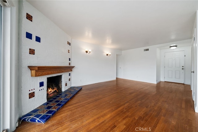 15408 Mottley Dr, La Mirada, CA 90638 - unfurnished living room with wood finished floors, a lit fireplace, and baseboards