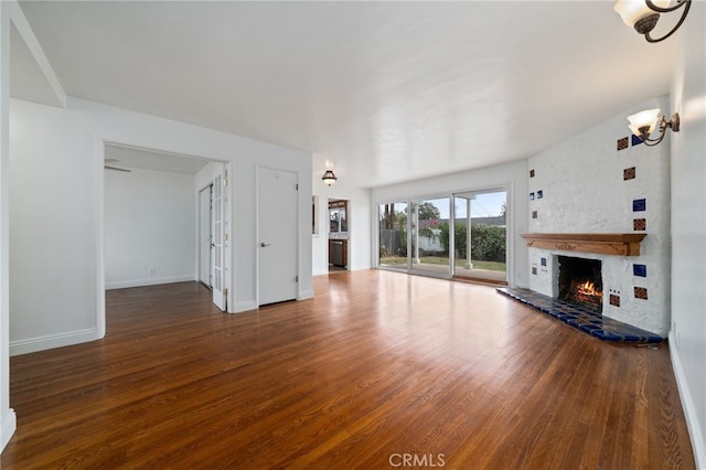 15408 Mottley Dr, La Mirada, CA 90638 - unfurnished living room featuring wood finished floors, a warm lit fireplace, baseboards, and a chandelier
