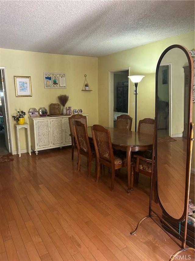 8900 Geyser Ave, Northridge, CA 91324 - dining area featuring dark wood-style flooring, a textured ceiling, and arched walkways