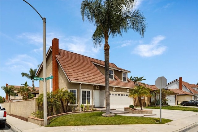 11396 Burl Dr, Fontana, CA 92337 - view of front of property with a tiled roof, driveway, an attached garage, stucco siding, and a chimney