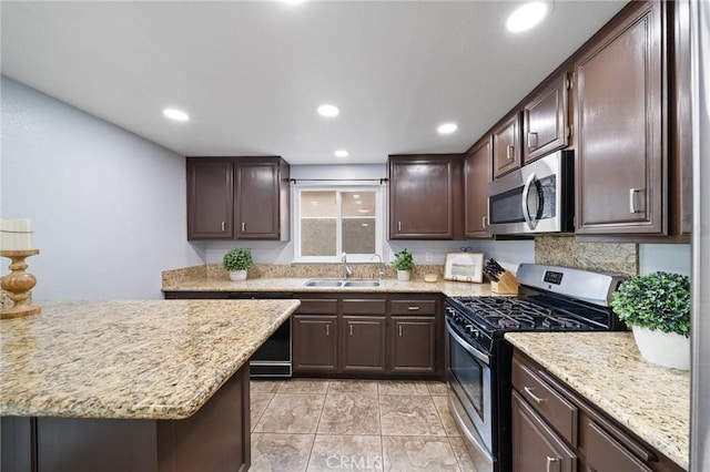 11396 Burl Dr, Fontana, CA 92337 - kitchen featuring appliances with stainless steel finishes, a sink, dark brown cabinets, recessed lighting, and light stone counters