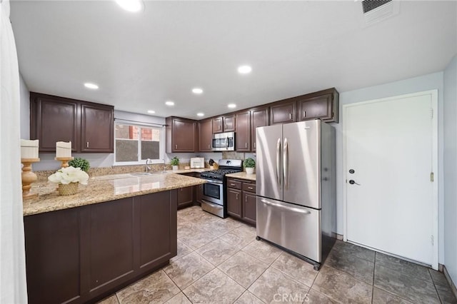 11396 Burl Dr, Fontana, CA 92337 - kitchen with appliances with stainless steel finishes, dark brown cabinets, a sink, light stone counters, and recessed lighting