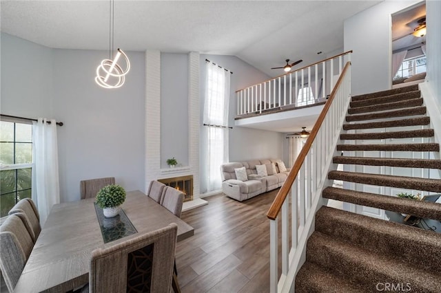 11396 Burl Dr, Fontana, CA 92337 - dining space with ceiling fan, stairway, high vaulted ceiling, and wood finished floors