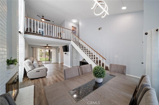 11396 Burl Dr, Fontana, CA 92337 - dining area featuring ceiling fan, a towering ceiling, stairs, wood finished floors, and baseboards
