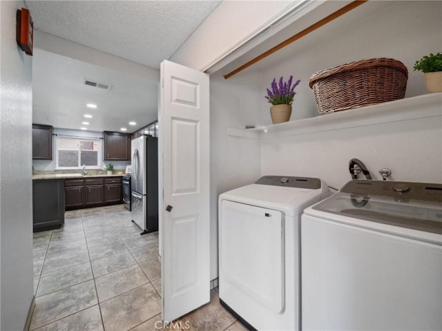 11396 Burl Dr, Fontana, CA 92337 - washroom with washing machine and clothes dryer, light tile patterned floors, and a textured ceiling