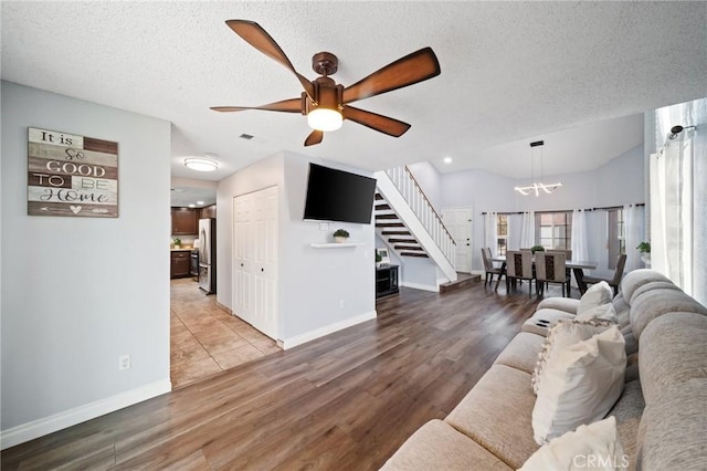 11396 Burl Dr, Fontana, CA 92337 - living area with stairway, a chandelier, baseboards, a textured ceiling, and a ceiling fan