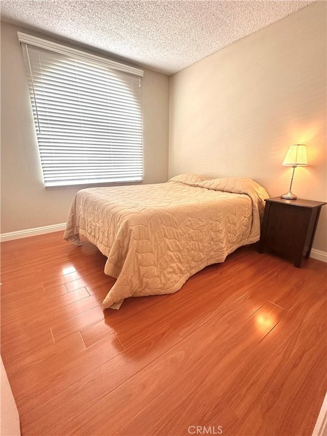 16511 Stonehaven Ct Unit 71, La Mirada, CA 90638 - bedroom with a textured ceiling, baseboards, and wood finished floors