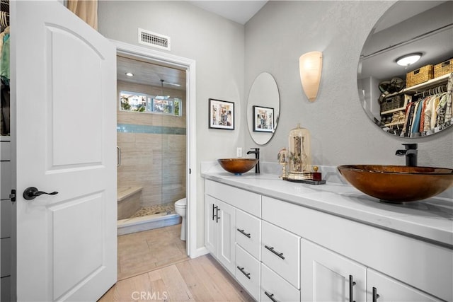 29386 Via Napoli, Laguna Niguel, CA 92677 - full bath with a shower stall, double vanity, toilet, a walk in closet, and wood finished floors