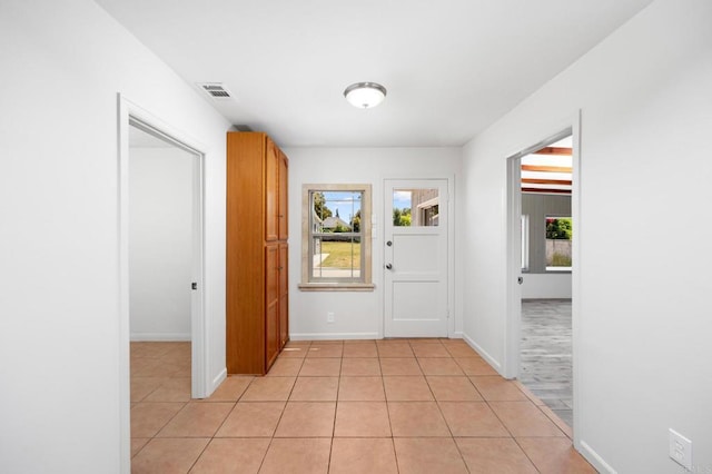hallway with light tile patterned floors and baseboards