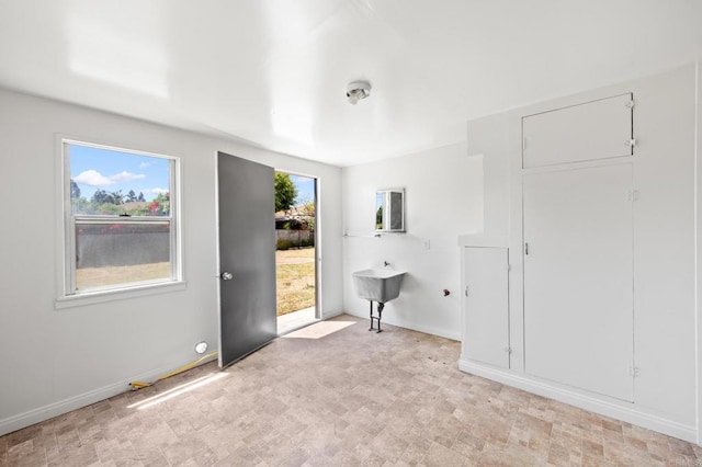 spare room with baseboards and light flooring