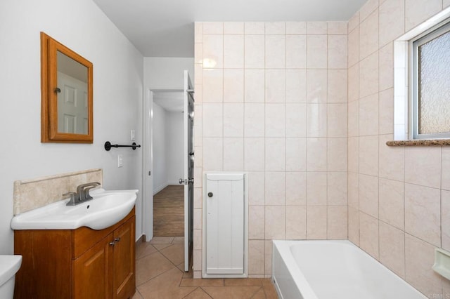 full bathroom featuring a bathtub, tile patterned floors, vanity, and toilet