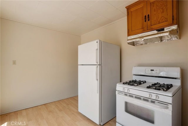29219 Lyon Dr, Cedar Glen, CA 92321 - kitchen featuring white appliances, under cabinet range hood, brown cabinets, and light wood-type flooring