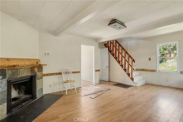29219 Lyon Dr, Cedar Glen, CA 92321 - unfurnished living room featuring wood finished floors, stairway, a tiled fireplace, and beamed ceiling