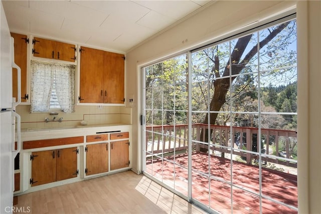 29219 Lyon Dr, Cedar Glen, CA 92321 - kitchen featuring light countertops, brown cabinets, light wood-type flooring, and a sink
