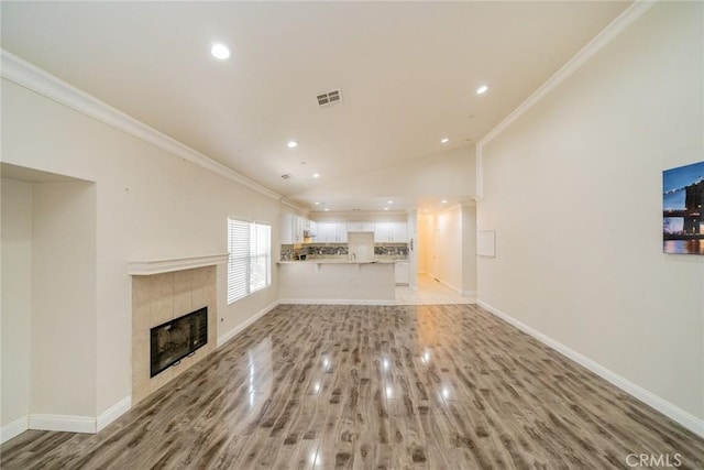 7404 Marshall Ct, Highland, CA 92346 - unfurnished living room featuring crown molding, light wood-type flooring, a fireplace, baseboards, and recessed lighting