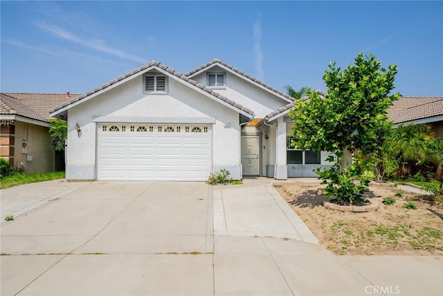 7404 Marshall Ct, Highland, CA 92346 - ranch-style home featuring driveway, stucco siding, an attached garage, and a tiled roof