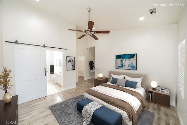 7404 Marshall Ct, Highland, CA 92346 - bedroom with a barn door, light wood-type flooring, baseboards, a high ceiling, and recessed lighting