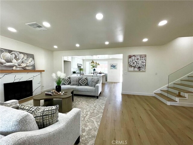 1616 Orchard Hill Ln, Hacienda Heights, CA 91745 - living area with light wood-type flooring, a fireplace, baseboards, stairs, and recessed lighting