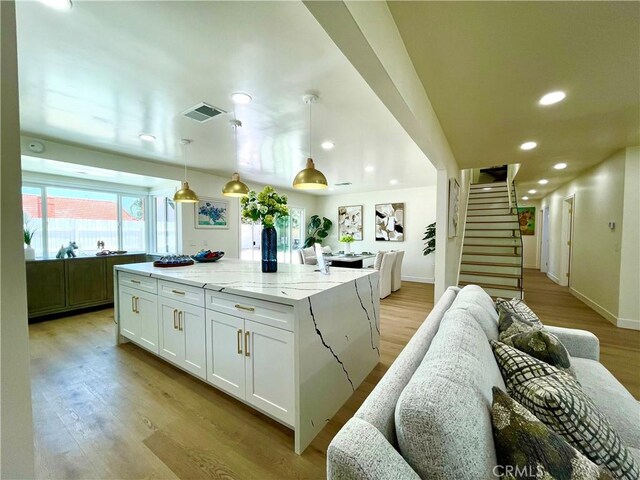1616 Orchard Hill Ln, Hacienda Heights, CA 91745 - kitchen featuring white cabinetry, light wood-style floors, a large island, light stone counters, and recessed lighting