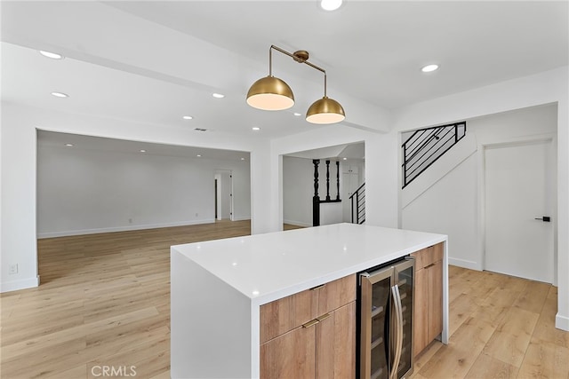 19617 Enslow Dr, Carson, CA 90746 - kitchen with beverage cooler, hanging light fixtures, modern cabinets, a center island, and light wood-type flooring