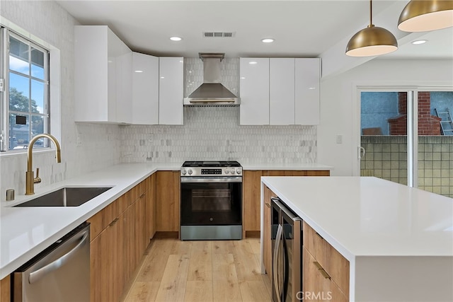 19617 Enslow Dr, Carson, CA 90746 - kitchen featuring modern cabinets, appliances with stainless steel finishes, a sink, wall chimney exhaust hood, and recessed lighting
