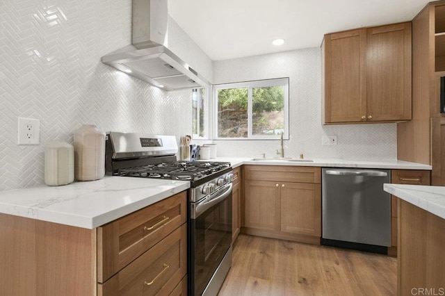 1744 Round Tree Dr, Oceanside, CA 92056 - kitchen with appliances with stainless steel finishes, wall chimney exhaust hood, a sink, light wood finished floors, and decorative backsplash