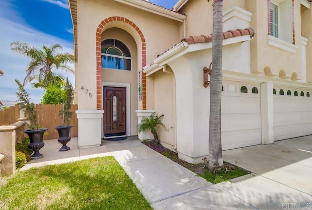 475 Marsh Harbor Dr, San Diego, CA 92154 - view of exterior entry with stucco siding, driveway, and an attached garage