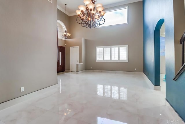 475 Marsh Harbor Dr, San Diego, CA 92154 - empty room featuring a chandelier, a towering ceiling, plenty of natural light, crown molding, and arched walkways