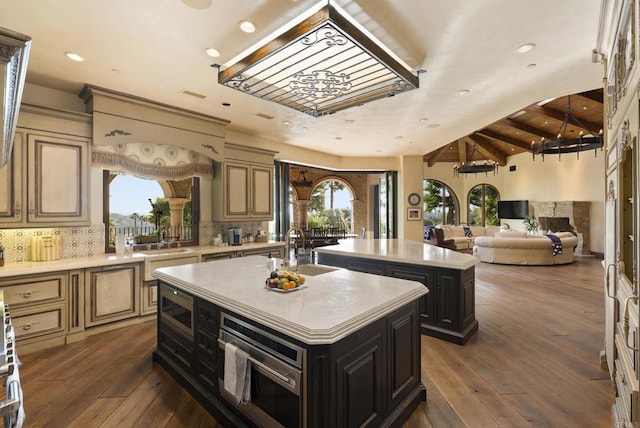 18127 Via Roswitha, Rancho Santa Fe, CA 92067 - kitchen with a center island with sink, a sink, dark cabinetry, light countertops, and recessed lighting