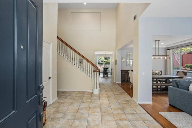 6628 Sitio Sago, Carlsbad, CA 92011 - entryway featuring stairway, a towering ceiling, and baseboards