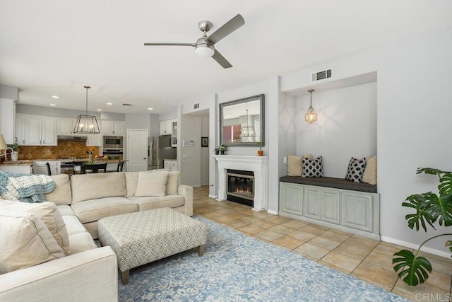 6628 Sitio Sago, Carlsbad, CA 92011 - living room featuring a ceiling fan, light tile patterned floors, a glass covered fireplace, baseboards, and recessed lighting