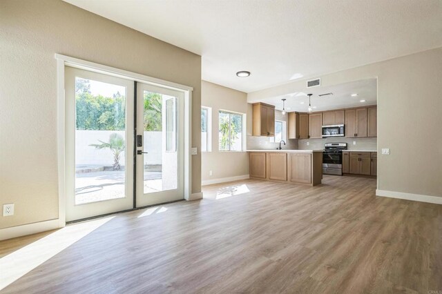 40550 Ventana Ct, Palm Desert, CA 92260 - unfurnished living room featuring baseboards, a sink, french doors, and light wood-style floors