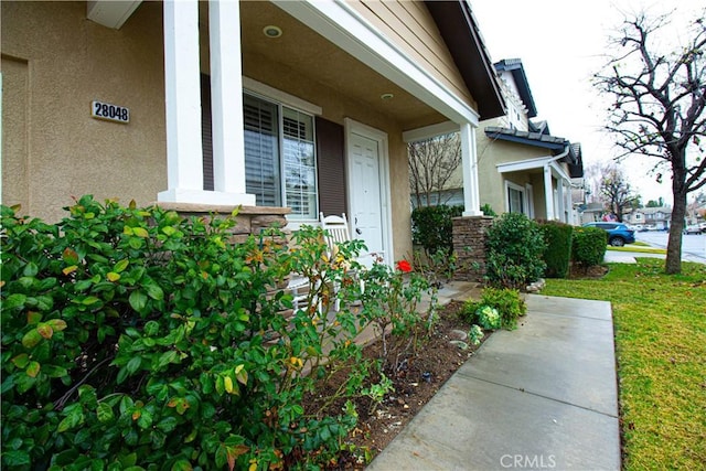 entrance to property featuring stucco siding and a porch