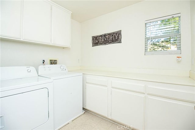 laundry room featuring cabinet space, washer and clothes dryer, and light floors