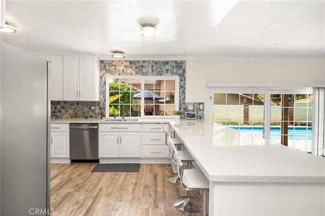 15541 Olive Branch Dr, La Mirada, CA 90638 - kitchen featuring appliances with stainless steel finishes, a sink, healthy amount of natural light, tasteful backsplash, and ornamental molding