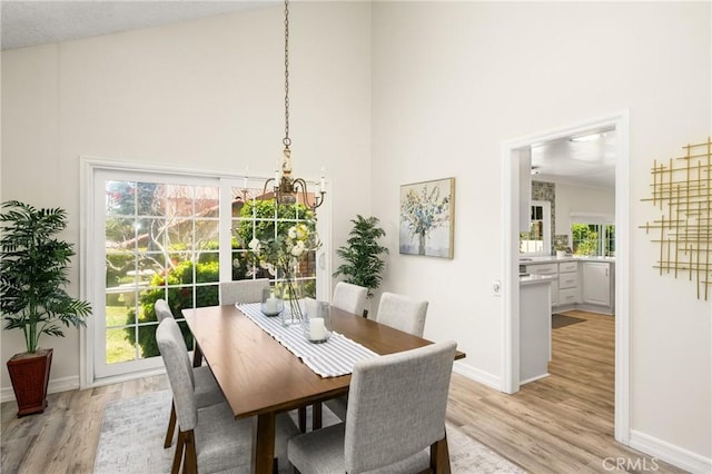 15541 Olive Branch Dr, La Mirada, CA 90638 - dining area with a towering ceiling, light wood finished floors, baseboards, and a chandelier
