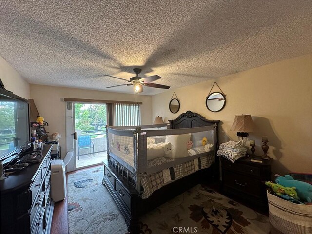 bedroom featuring access to exterior, a textured ceiling, and a ceiling fan